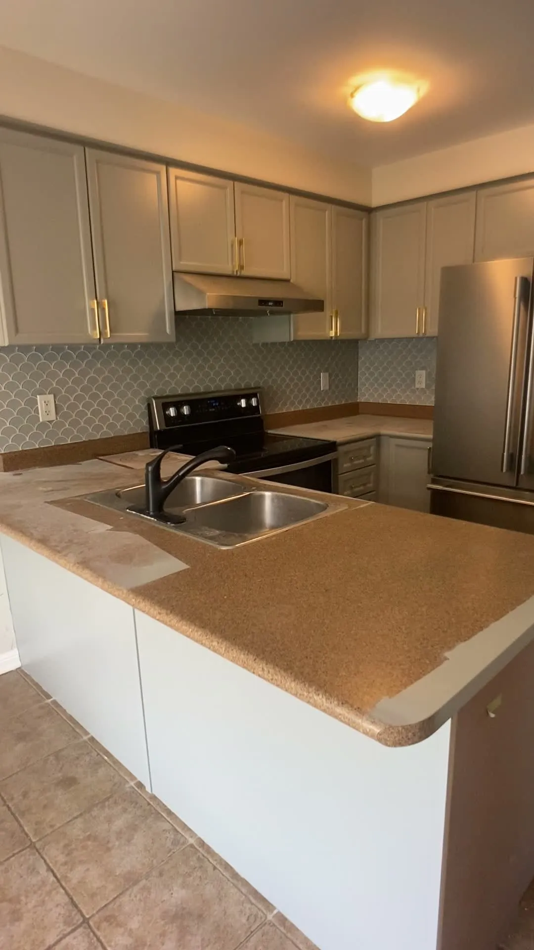 A walk around the finished West Oak Trails kitchen — honey oak refinished light grey with brass handles, the original laminate counters and patterned backsplash still in place