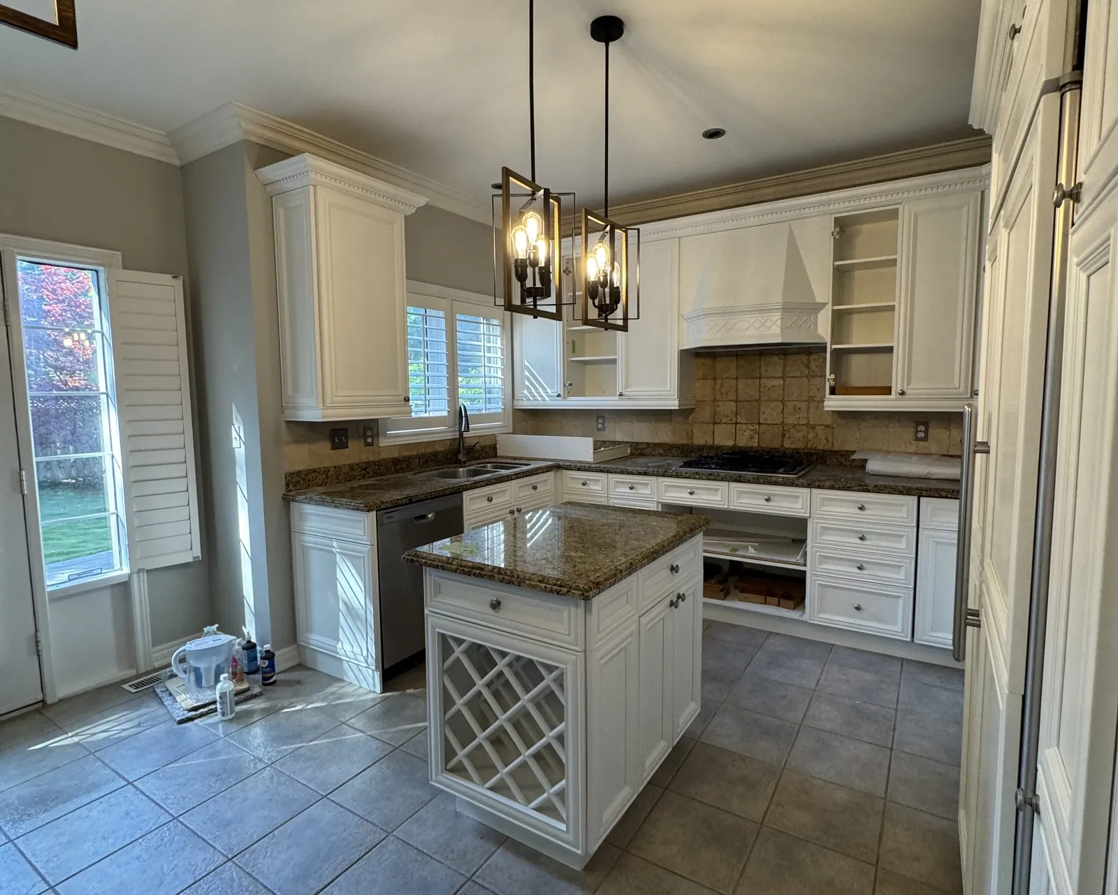 After — Kitchen island upgrade in Clearview, Oakville — the island's lattice wine rack kept and refinished in white, with new pendants hung over it