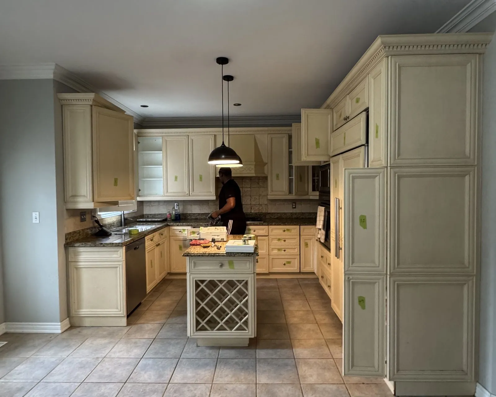 Before — Kitchen island upgrade in Clearview, Oakville — the island's lattice wine rack kept and refinished in white, with new pendants hung over it