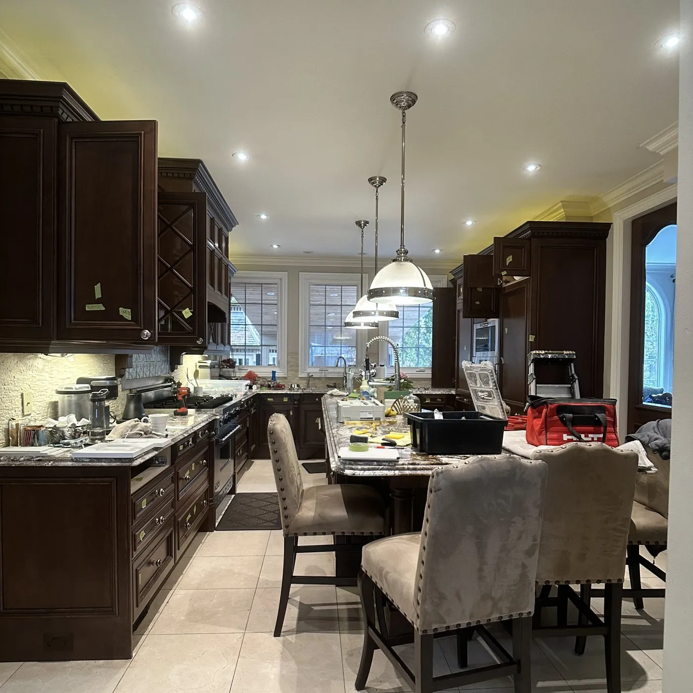 Before — Quartz countertop replacement in Ford, Oakville — dark granite replaced with white quartz, the cabinets sprayed white over black in the same project
