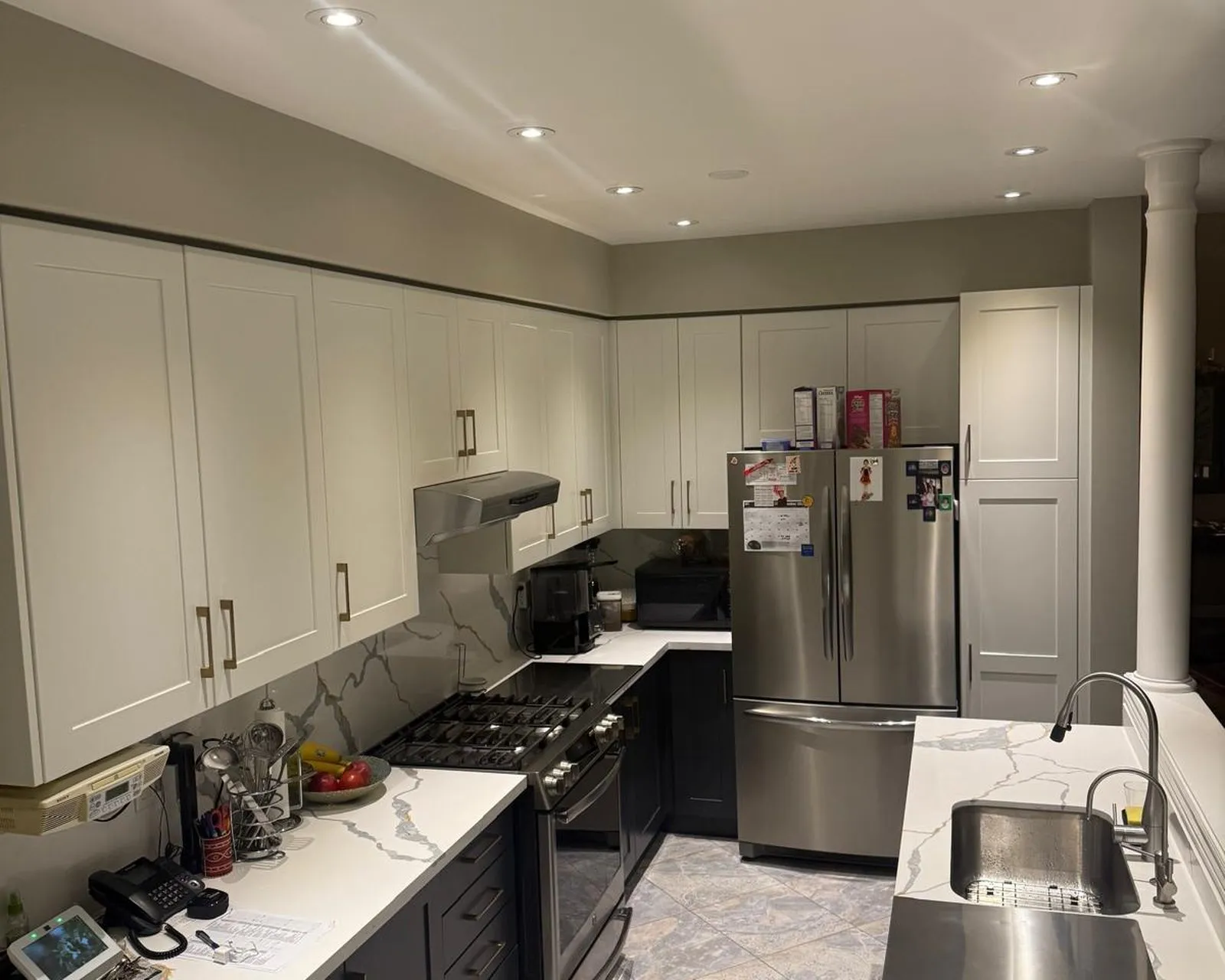 After — Quartz countertop replacement in Oak Park, Oakville — dark granite on oak cabinetry replaced with Calacatta-look quartz, carried up the wall as a slab backsplash