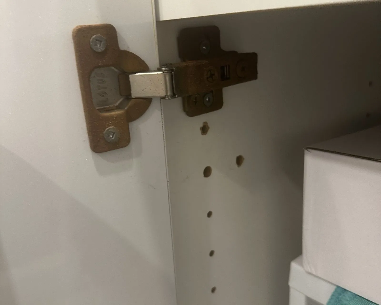 Before — Soft-close hinge upgrade in Bronte Creek, Oakville — the original worn hinge in the cabinet frame, then the soft-close hinge fitted in the same holes