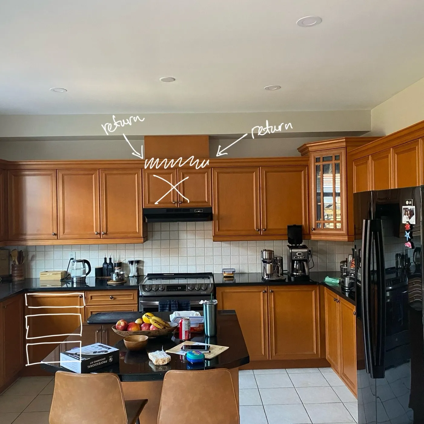 Before — Spray painting in Oakville — oak cabinetry sprayed white above and navy below, with a new hood and backsplash