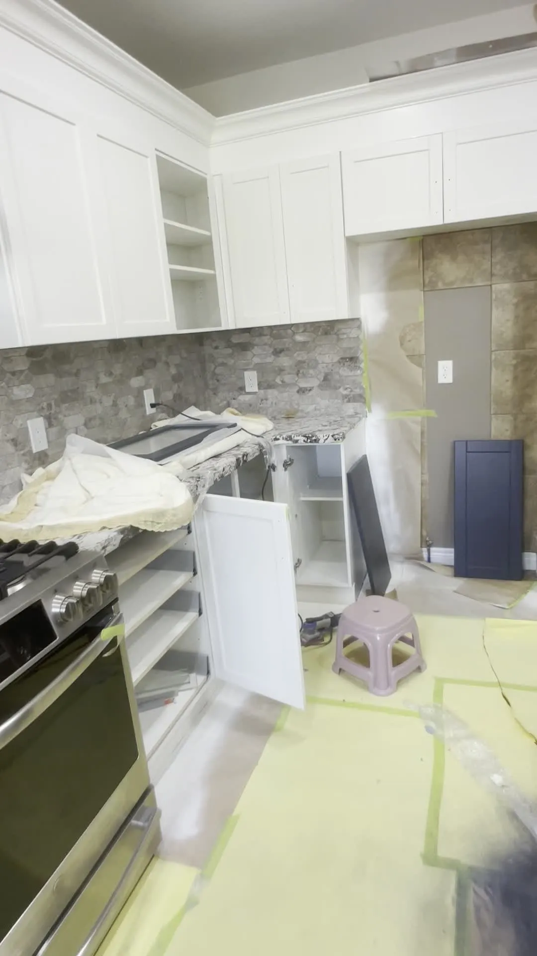 A walk through the finished Jerome kitchen — white perimeter cabinetry with a charcoal island under the original granite, brass handles throughout