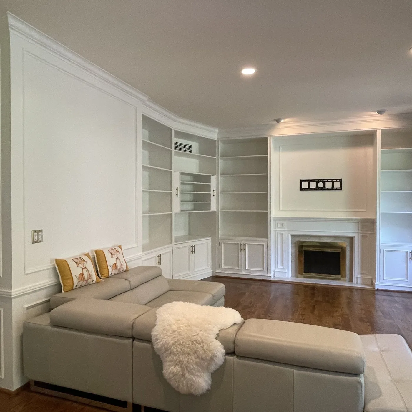 After — Wood painting in The Preserve, Oakville — dark oak built-in shelving, fireplace surround and wall panelling sprayed white