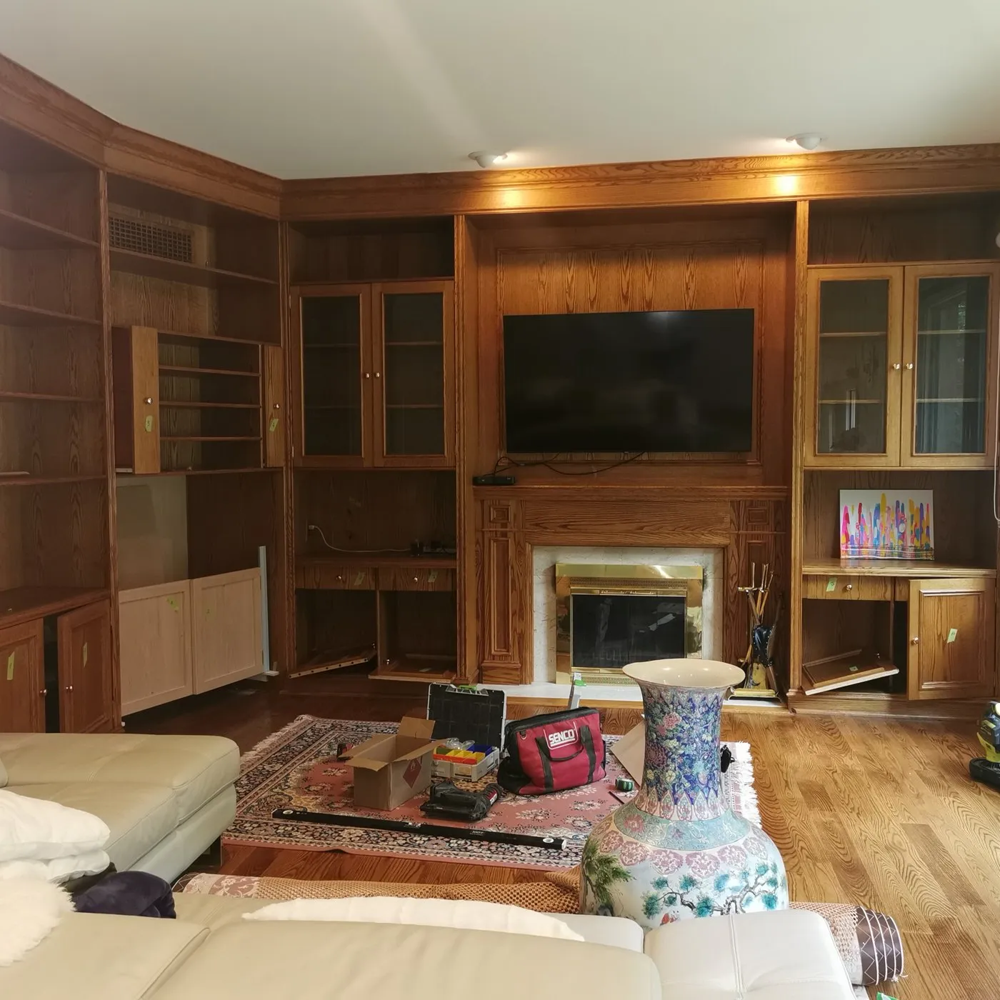 Before — Wood painting in The Preserve, Oakville — dark oak built-in shelving, fireplace surround and wall panelling sprayed white