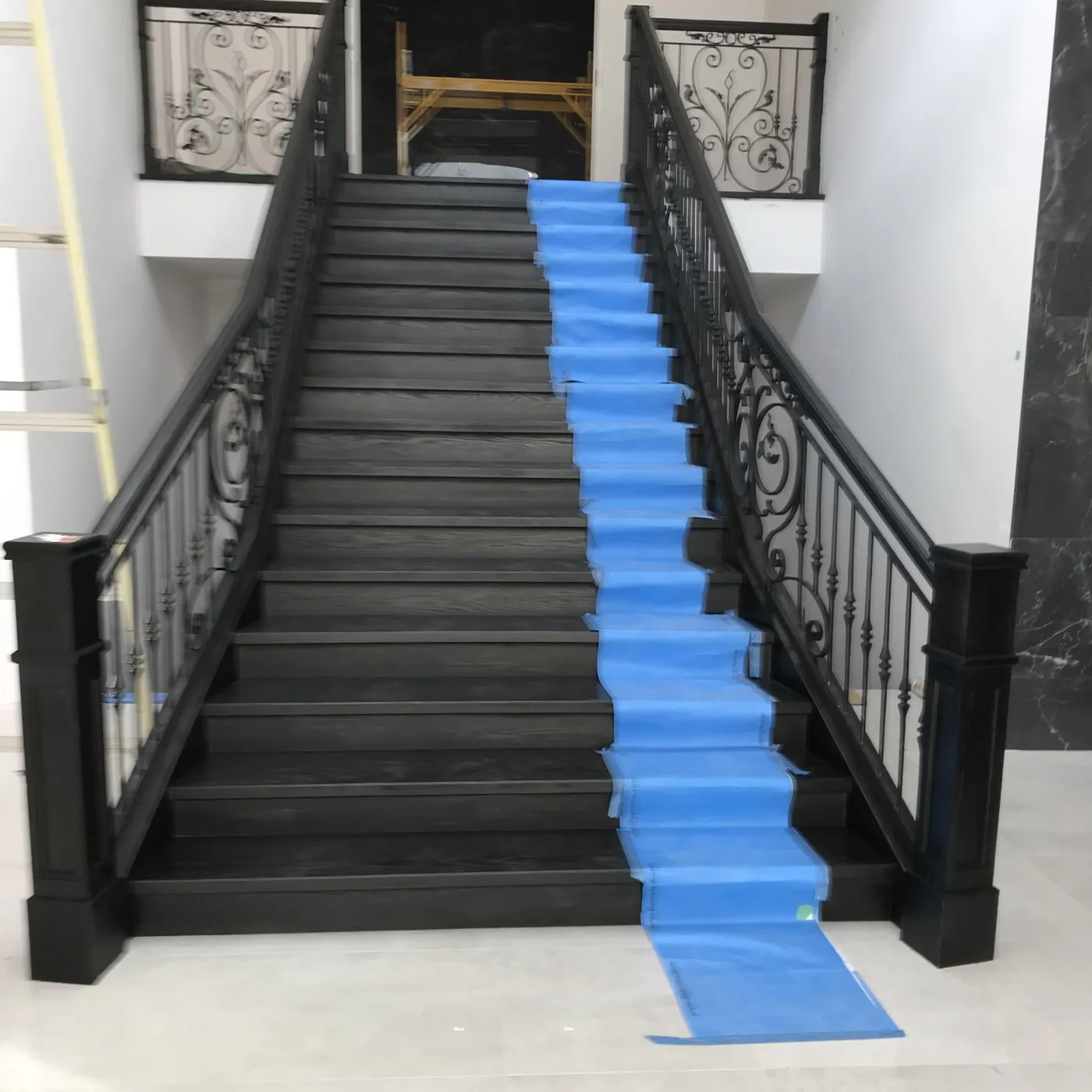 After — Wood staining in Bronte Creek, Oakville — a bare oak staircase stripped and stained near-black, the wrought-iron balustrade left in place