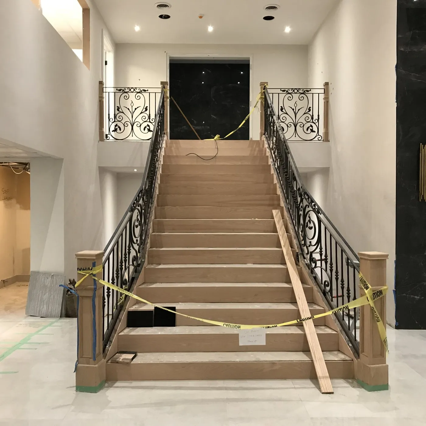 Before — Wood staining in Bronte Creek, Oakville — a bare oak staircase stripped and stained near-black, the wrought-iron balustrade left in place
